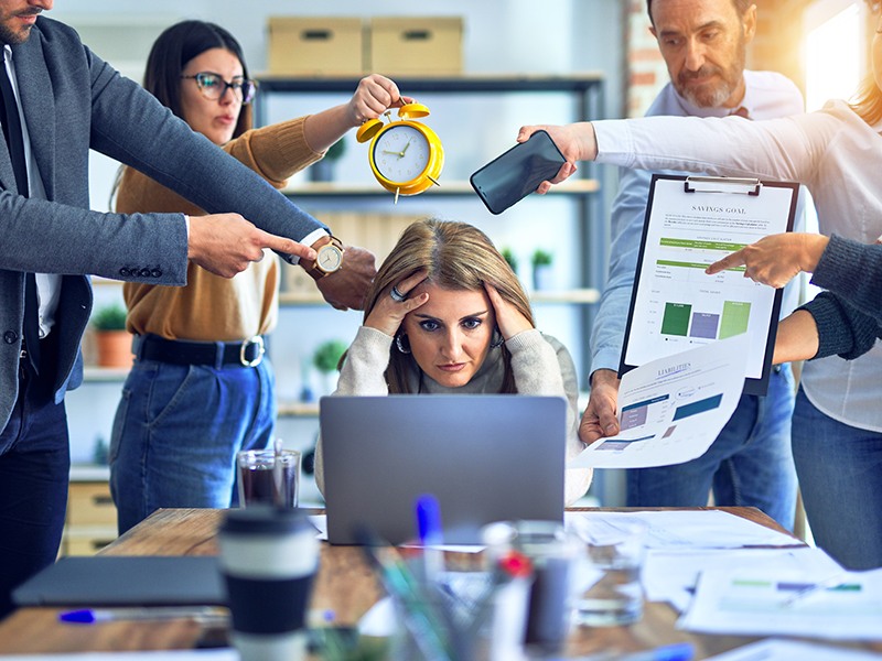 Office worker at desk with laptop under pressure
